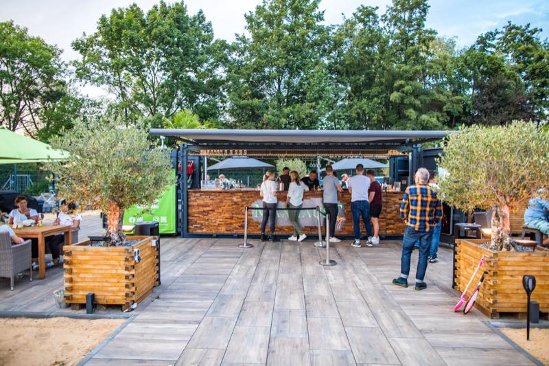 Gäste am 360-Grad-Barcontainer auf der Terrasse der Maxhaust Lounge