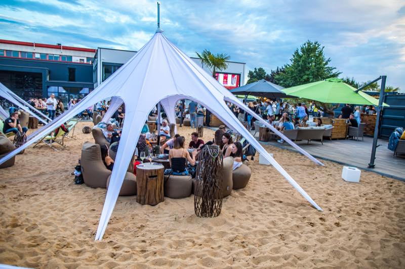 Sternzelt im Sandbereich mit Sitzsäcken und Gästen
