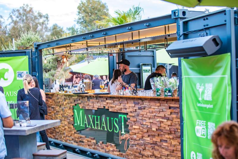 Barkeeper am beleuchteten Barcontainer der Maxhaust Lounge