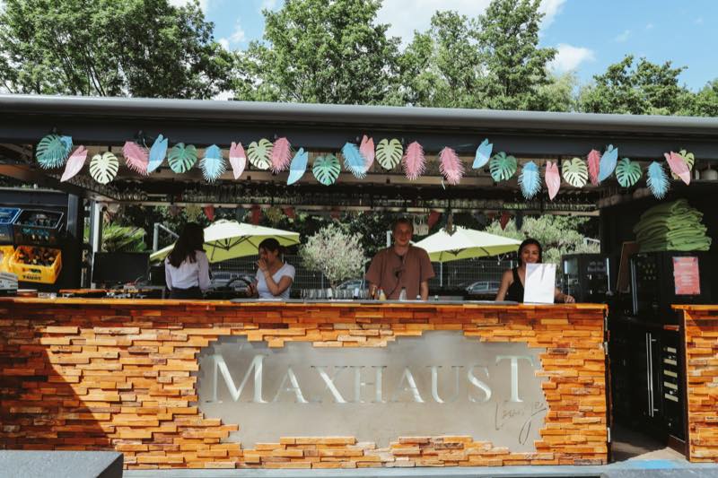 Barteam am Barcontainer mit sommerlicher Papierdeko