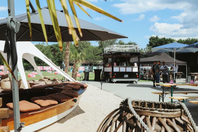 Beach-Bereich mit Boot-Sitzbank, mobiler Bar und Biertischen