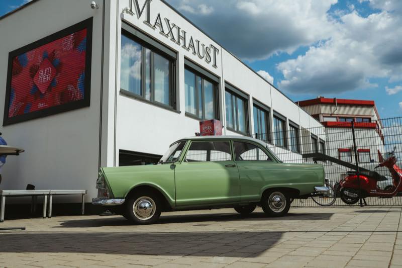 Oldtimer und Motorroller vor dem Maxhaust-Gebäude